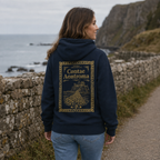 Woman wearing the navy Antrim Heritage Hoodie from the back on a quiet coastal path