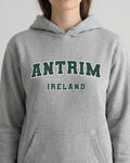 Gray hoodie with 'Antrim Ireland' text worn by a person on a light gray background