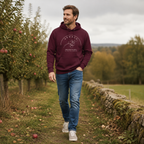 Man wearing the Armagh Blossom maroon hoodie in an Armagh orchard